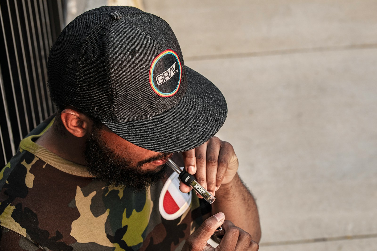 man in black and green camouflage hat holding black and white smartphone